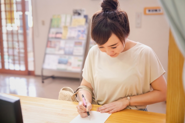 書類を記入してる女性　画像